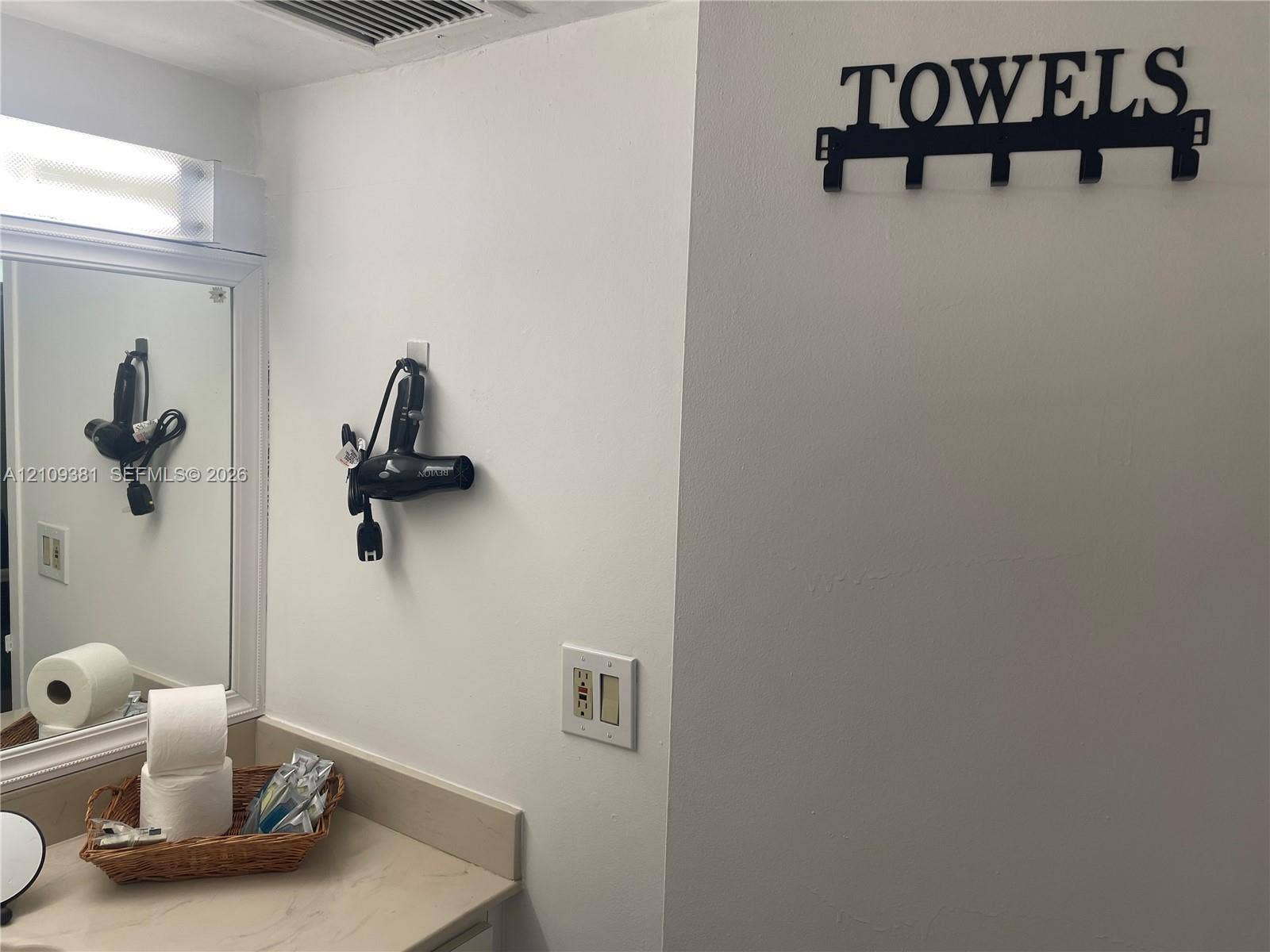 26 Diplomat Parkway, #2351, Hallandale Beach, FL 33009 Bathroom featuring a vanity with a solid-surface integrated sink, white cabinetry, a large wall mirror, and white tile wall accents