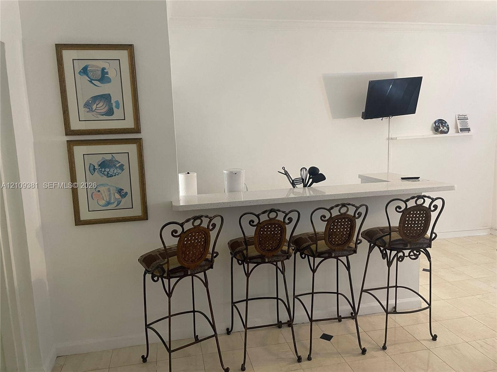 26 Diplomat Parkway, #2351, Hallandale Beach, FL 33009 Interior space featuring light-toned tile flooring, crown molding, and a built-in wall shelf