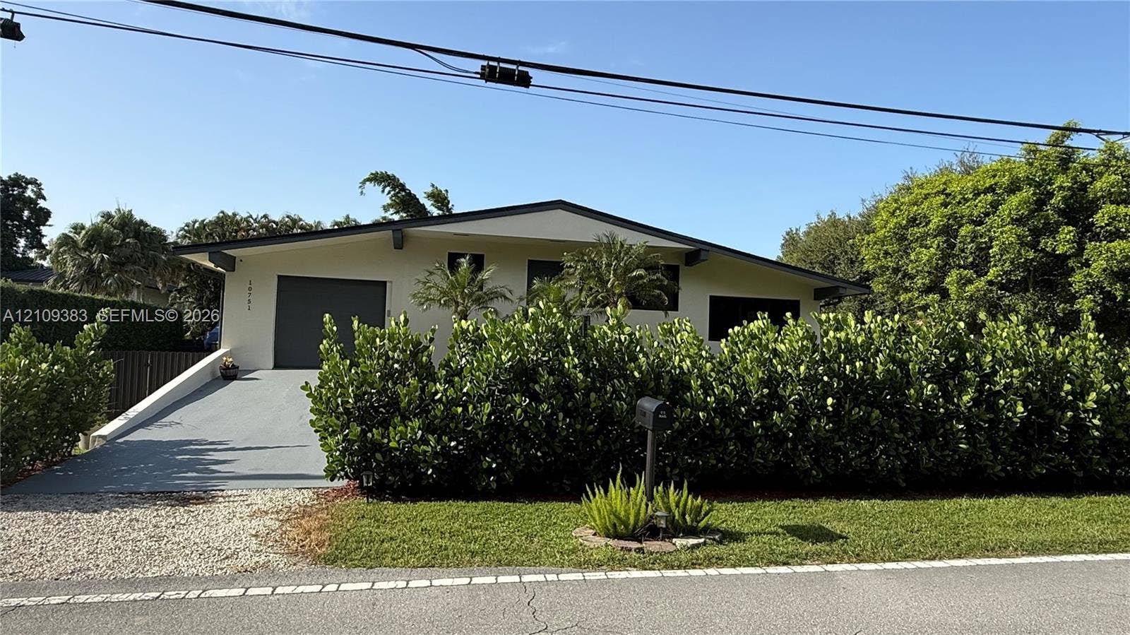 10751 SW 48th Street, Davie, Davie, FL 33328 Single-story residence featuring a low-slope roof, stucco exterior, integrated garage, and a paved driveway