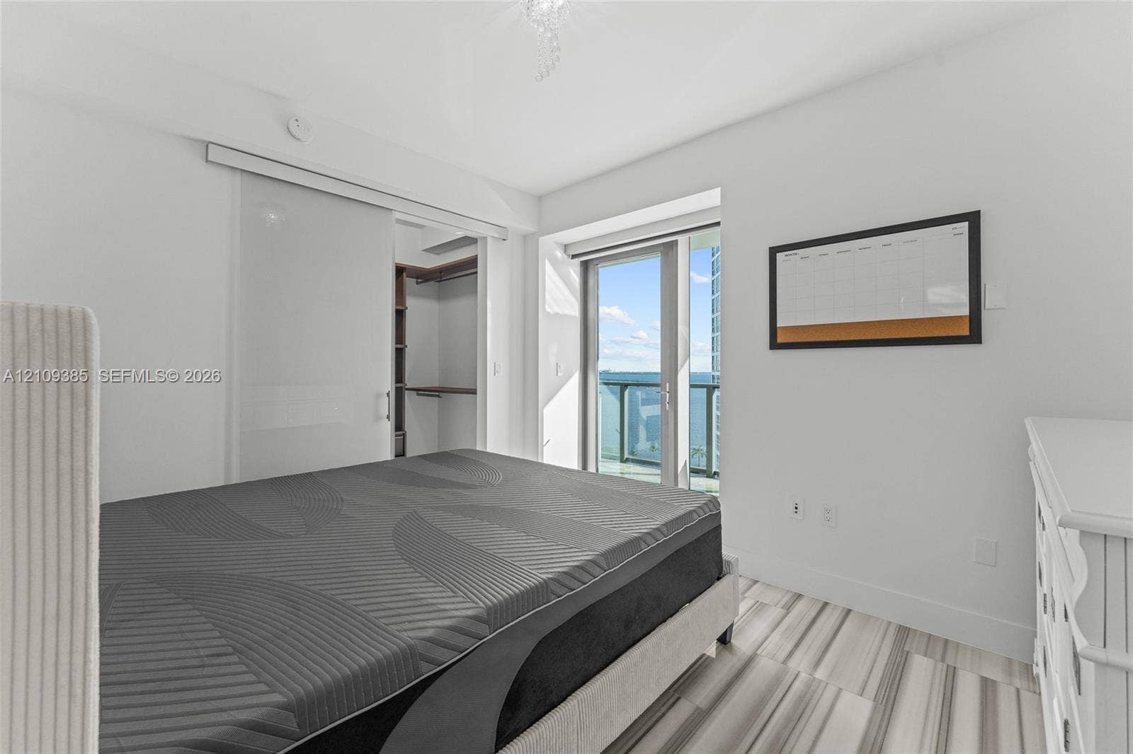 Room featuring tile flooring, sliding glass door access to a balcony, and a built-in walk-in closet with integrated shelving
