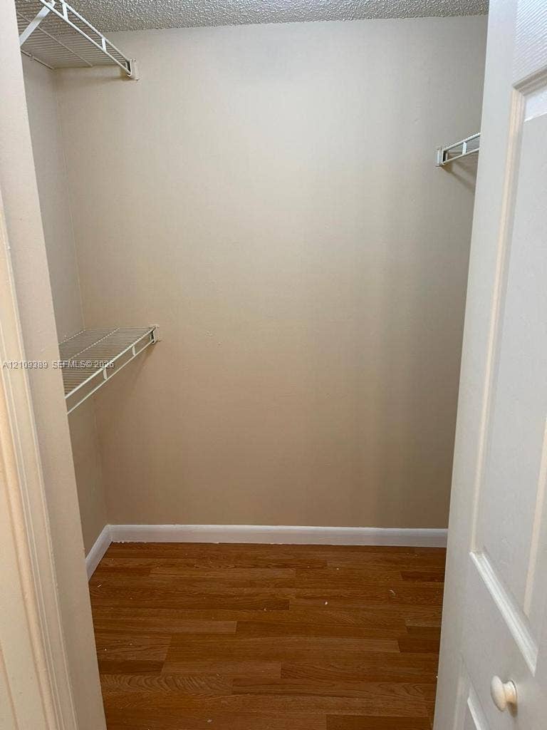 Storage area featuring wood-finish flooring and dual-level wire shelving