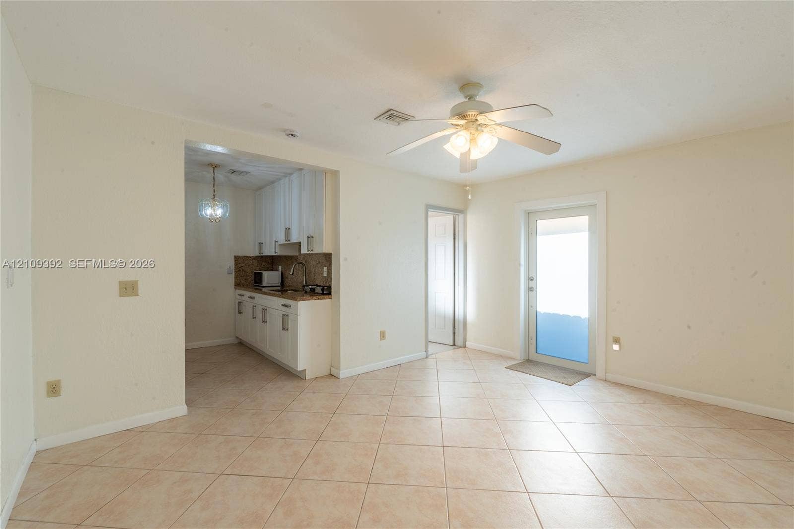 7641 Raleigh Street, #1, Hollywood, Hollywood, FL 33024 Tile flooring, ceiling-mounted light fixture with a fan, and white cabinetry featuring stone-surface countertops
