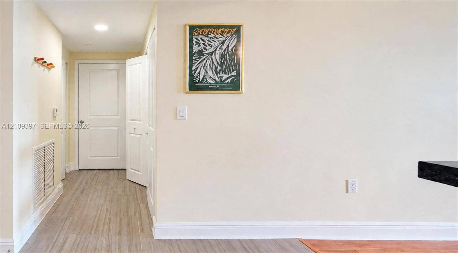 Neutral-toned interior featuring wood-finish flooring, recessed lighting, and white six-panel doors