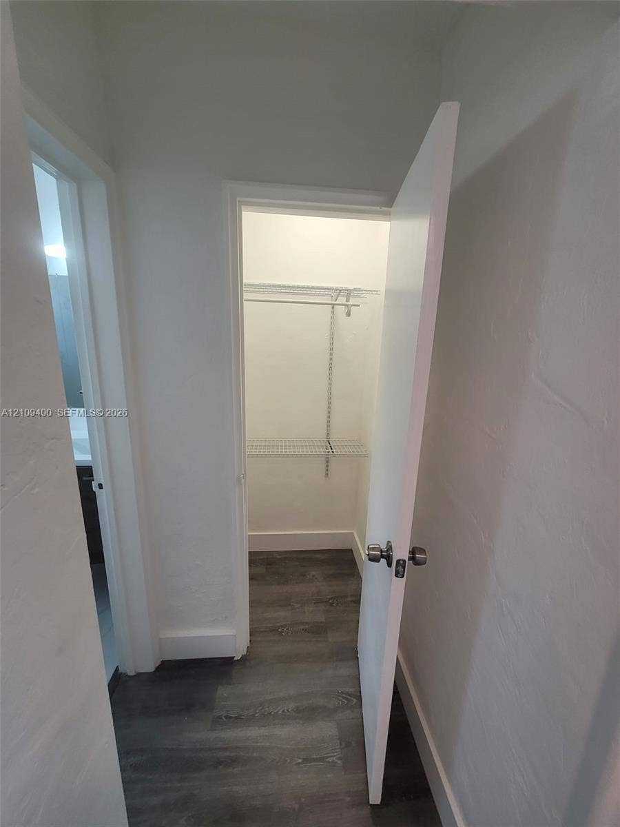 Interior storage closet featuring wire shelving and wood-finish flooring