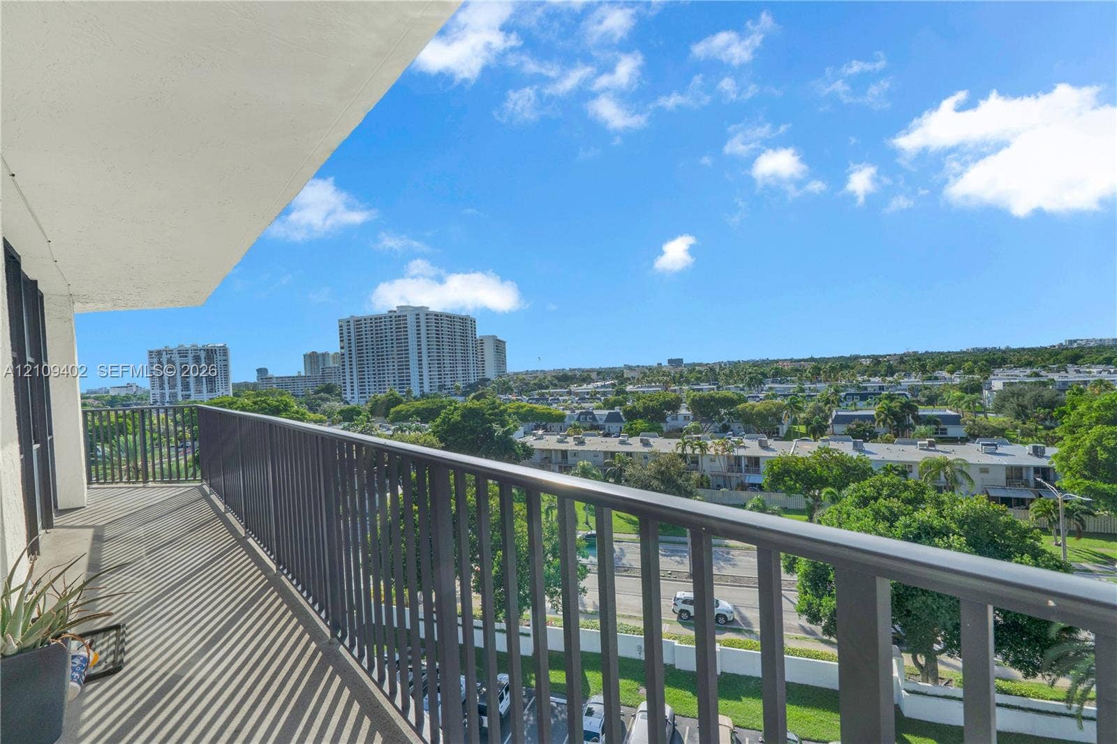 Covered balcony featuring metal railings and concrete flooring