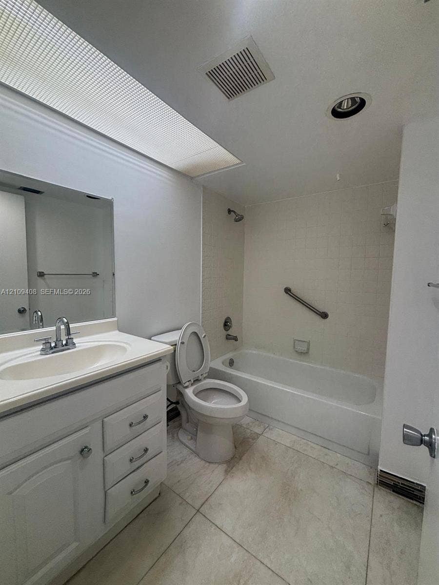 12600 SW 5th Court, #208L, Pembroke Pines, Pembroke Pines, FL 33027 Bathroom featuring a skylight, vanity with an integrated sink and chrome faucet, tile flooring, and a bathtub with a tile surround