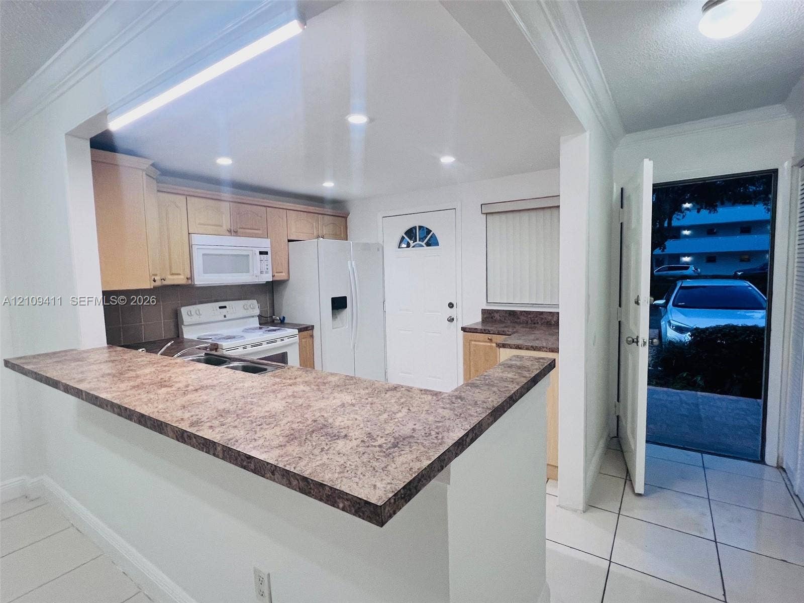 Kitchen featuring a peninsula countertop, light-finish cabinetry, tile flooring, and recessed lighting