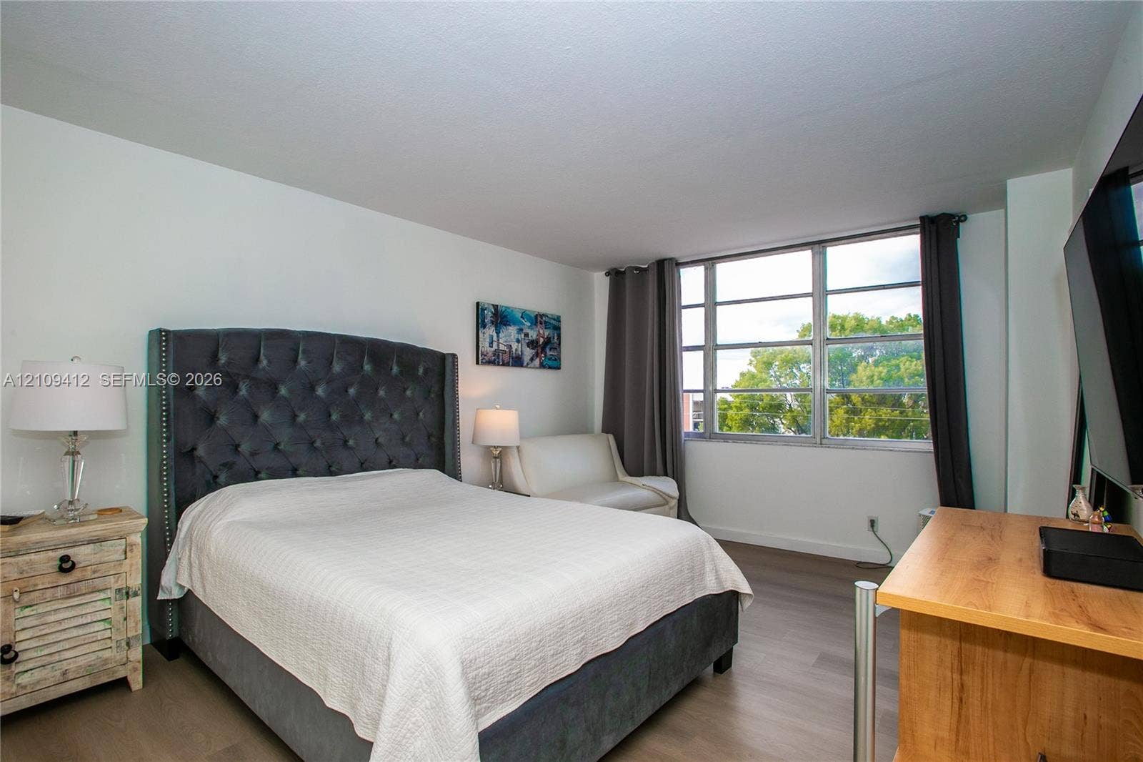 137 Golden Isles Drive, #408, Hallandale Beach, FL 33009 Room featuring wood-finish flooring, a large multi-pane window, and neutral walls