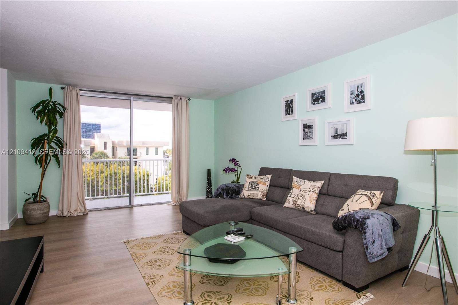 137 Golden Isles Drive, #408, Hallandale Beach, FL 33009 Living area featuring wood-finish flooring and sliding glass doors with access to an exterior balcony