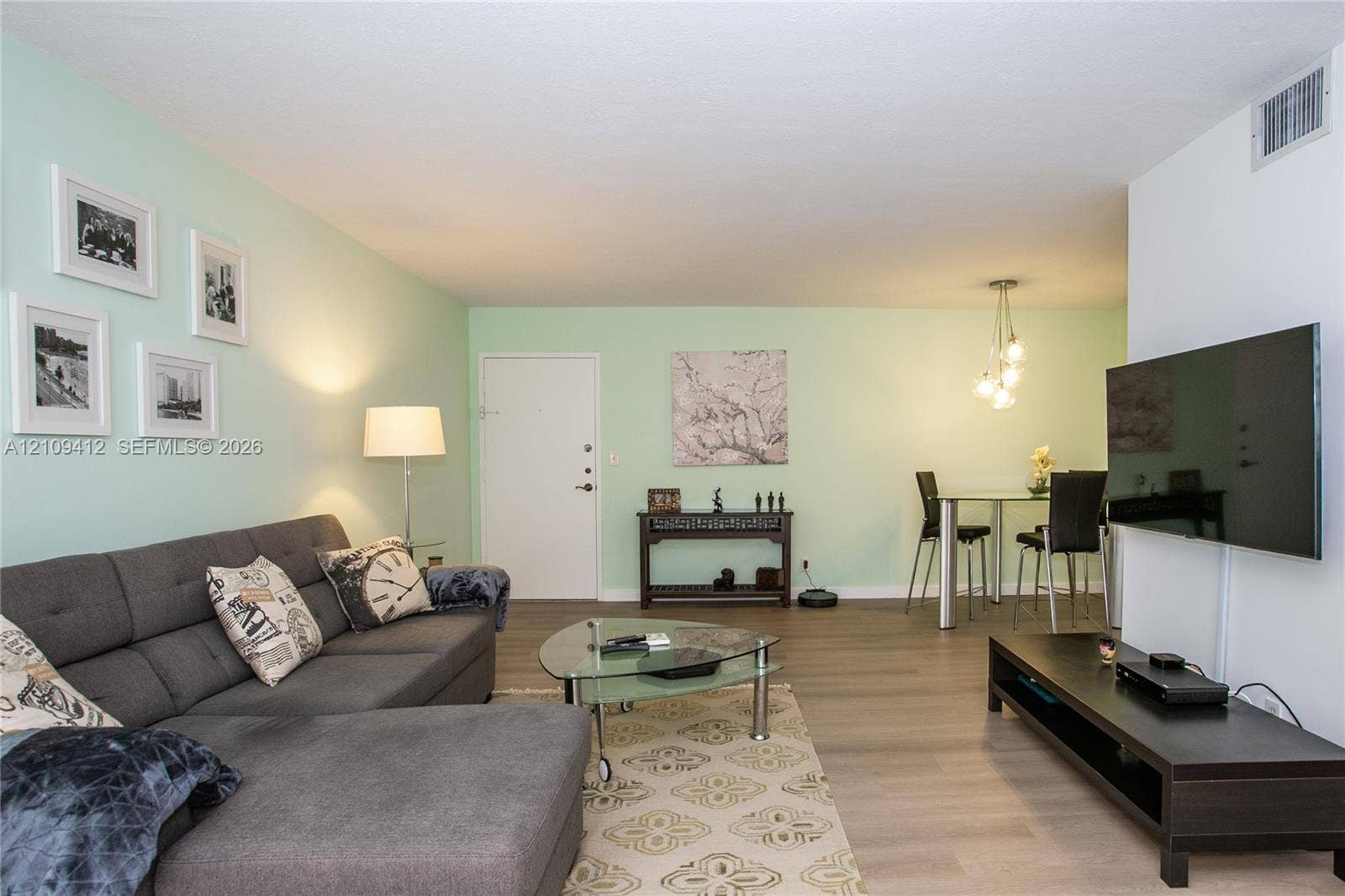 137 Golden Isles Drive, #408, Hallandale Beach, FL 33009 Open-concept interior featuring wood-finish flooring and a multi-pendant light fixture