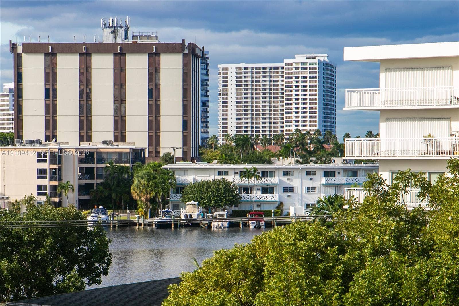 137 Golden Isles Drive, #408, Hallandale Beach, FL 33009 Waterfront property featuring a private boat dock and mature tropical landscaping