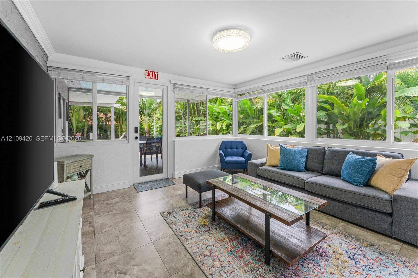 1955 Thomas Street, Hollywood, FL 33020 Sunroom featuring expansive windows, tile flooring, crown molding, and a flush-mount light fixture