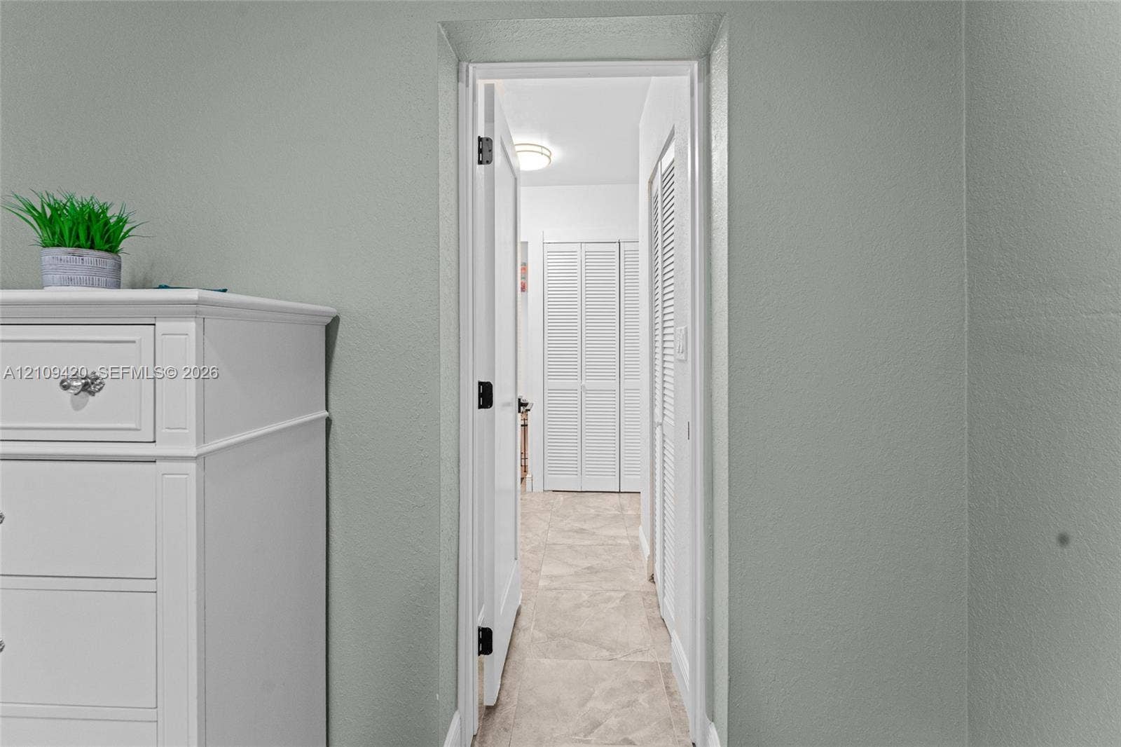 1955 Thomas Street, Hollywood, FL 33020 Neutral-toned interior walls featuring light-colored tile flooring and white louvered closet doors with flush-mount lighting