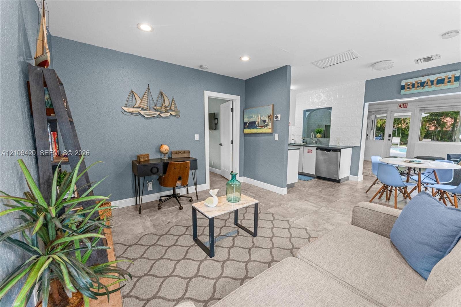 1955 Thomas Street, Hollywood, FL 33020 Living area featuring large-format tile flooring, recessed lighting, and a kitchen workspace with stainless steel appliances and crisp white cabinetry