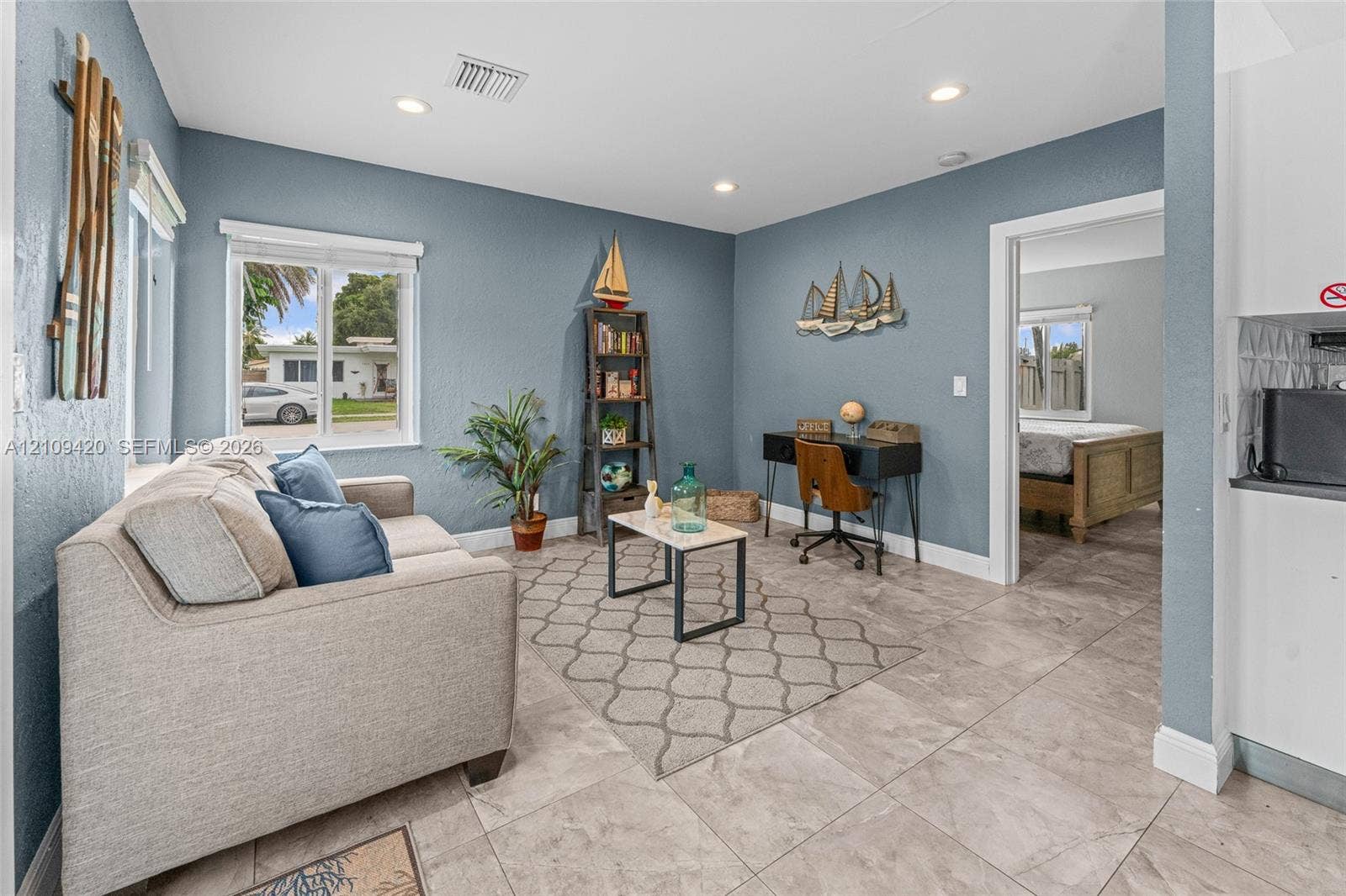 1955 Thomas Street, Hollywood, FL 33020 Living area featuring neutral-toned tile flooring, recessed lighting, and a window providing natural light