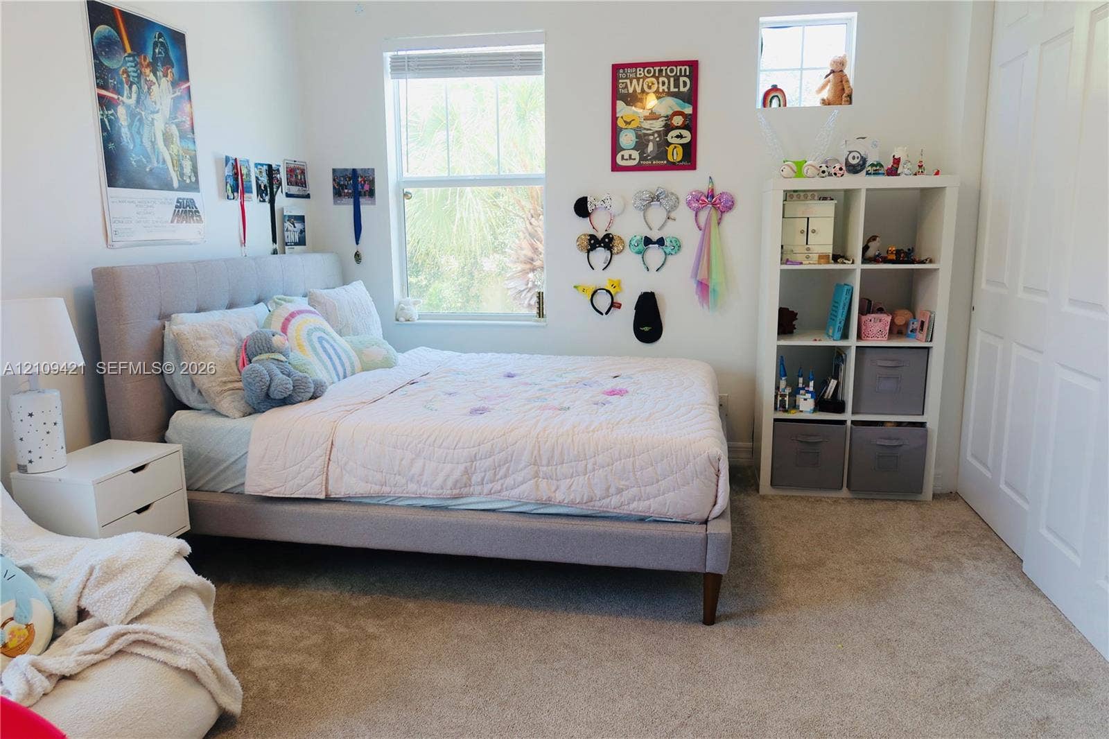 Neutral-toned interior space featuring carpeting, a multi-pane window, a small square window, and a paneled closet door