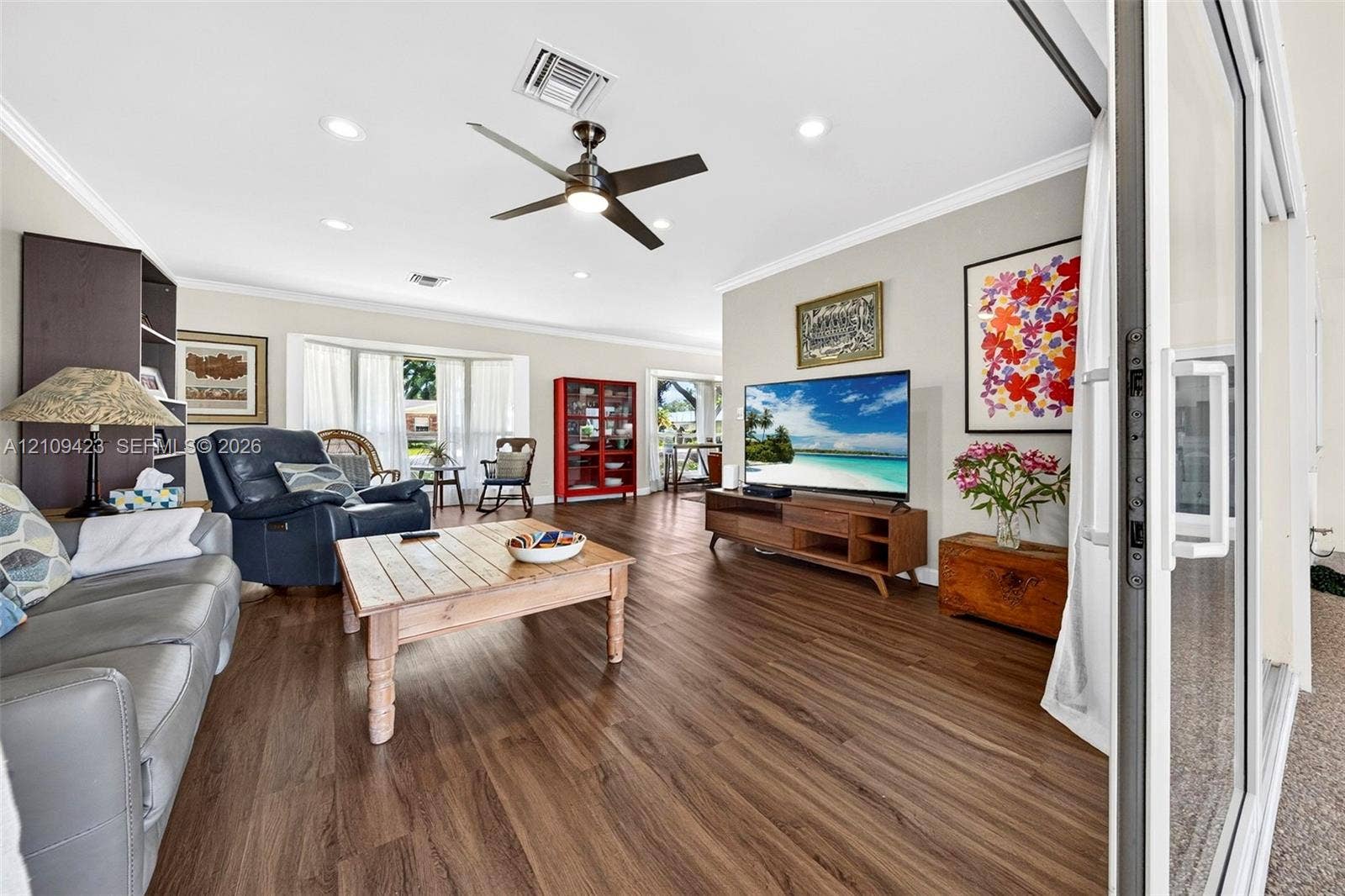 Living area featuring wood-finish flooring, recessed lighting, a modern ceiling fan, and sliding glass patio doors