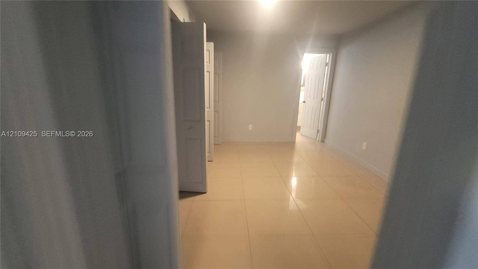 615 NW 25th Court, #B, Miami, Miami, FL 33125 Neutral-toned room featuring large-format tile flooring and bi-fold closet doors