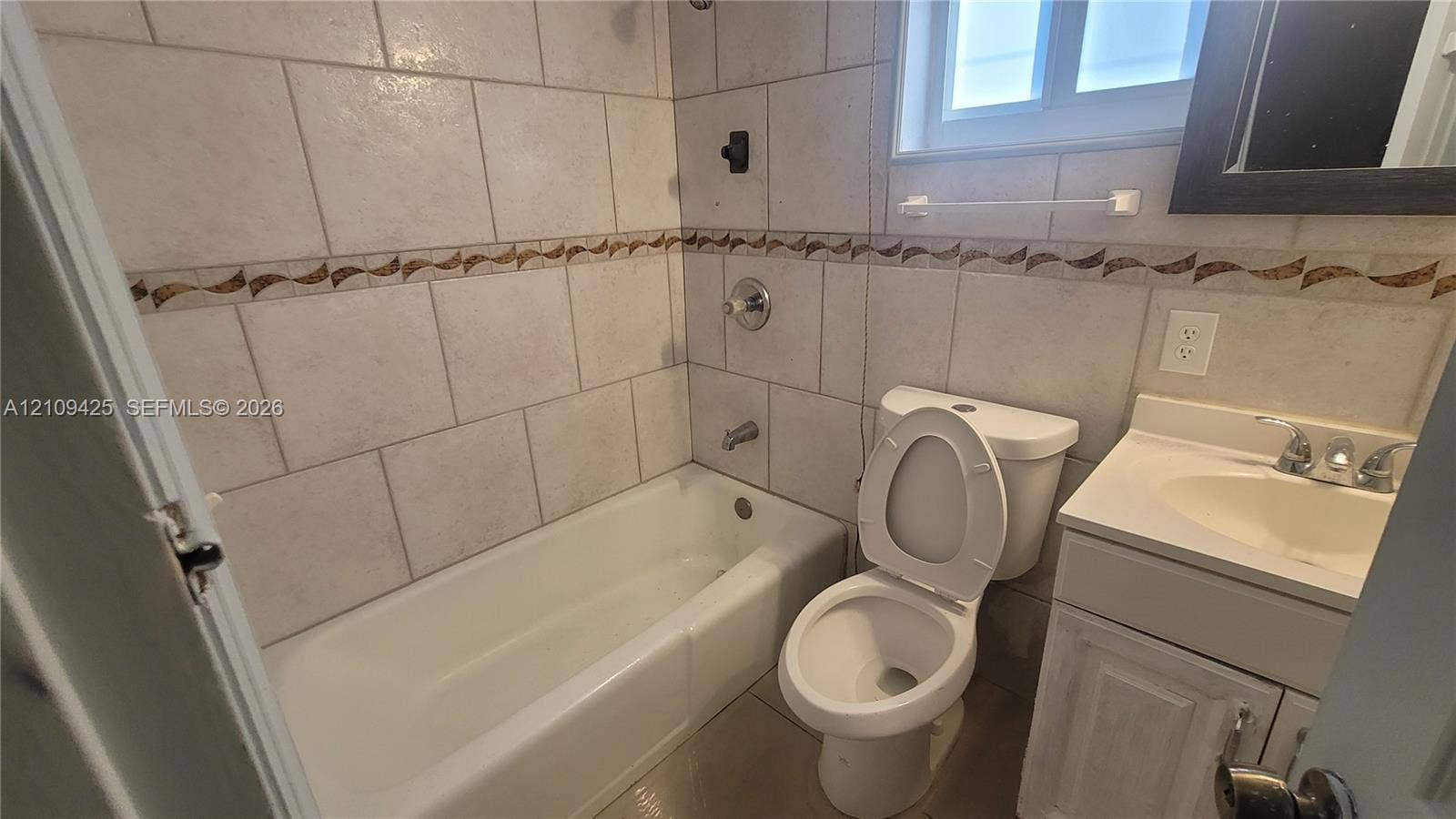 615 NW 25th Court, #B, Miami, Miami, FL 33125 Bathroom featuring wall-to-wall ceramic tiling, decorative tile inlay, integrated vanity, and shower-tub combination