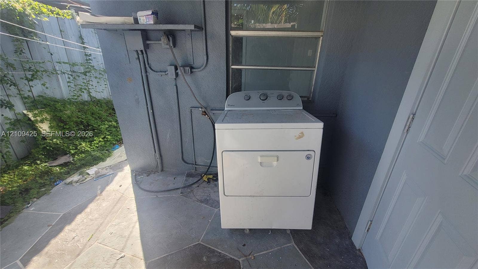 615 NW 25th Court, #B, Miami, Miami, FL 33125 Exterior area featuring a concrete-tiled floor, masonry walls, and a dedicated laundry appliance hookup