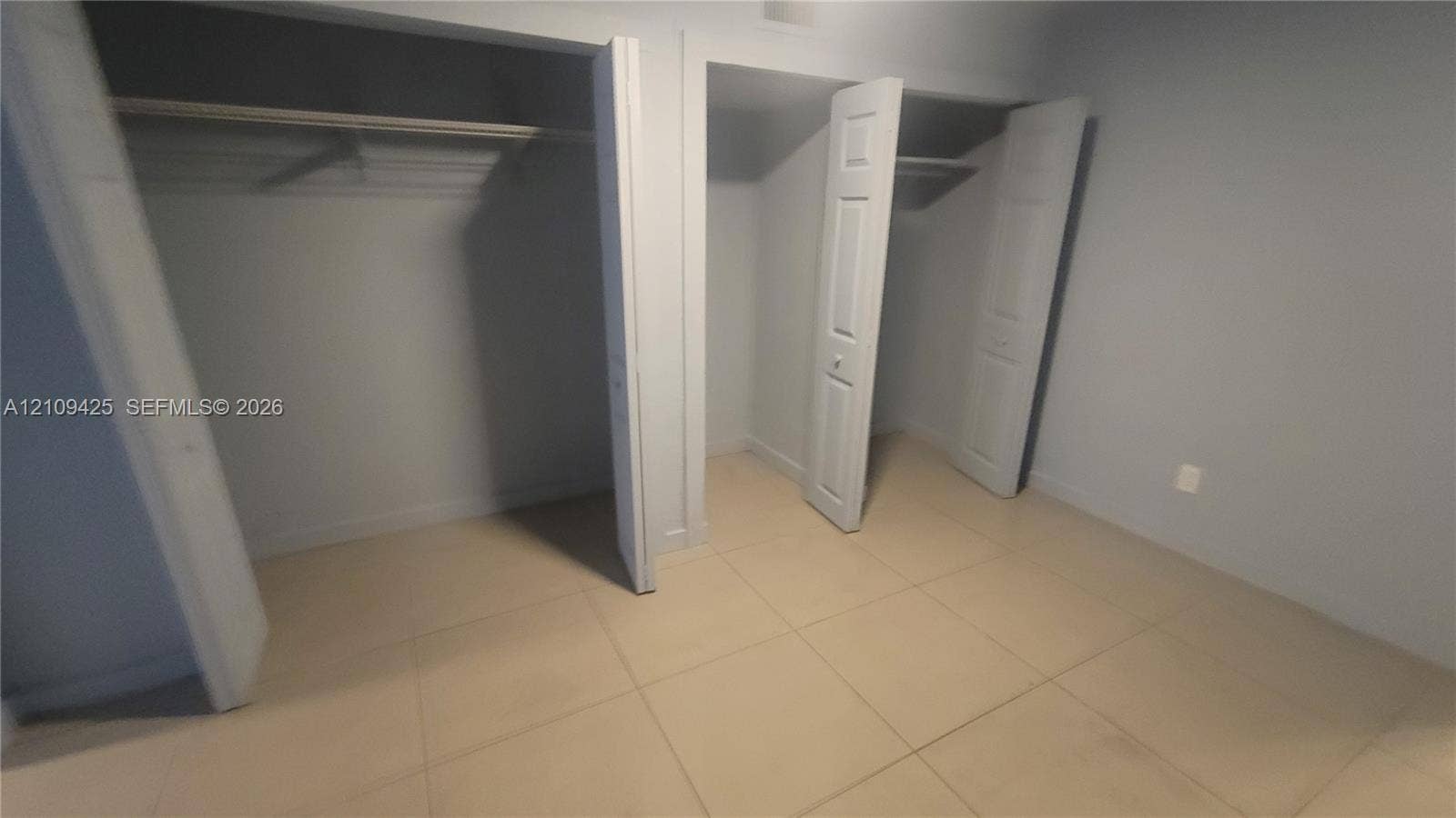 615 NW 25th Court, #B, Miami, Miami, FL 33125 Interior space featuring ceramic tile flooring, two separate closets with paneled doors, and built-in shelving