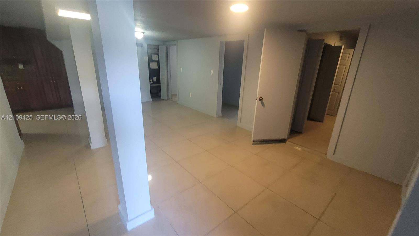615 NW 25th Court, #B, Miami, Miami, FL 33125 Large-format tile flooring, structural support column, recessed lighting, and built-in wood cabinetry