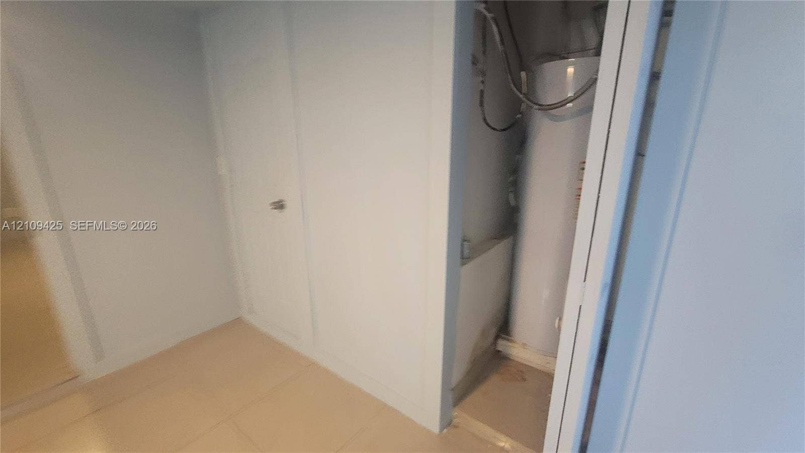 615 NW 25th Court, #B, Miami, Miami, FL 33125 Mechanical space featuring a water heater and solid-core interior door