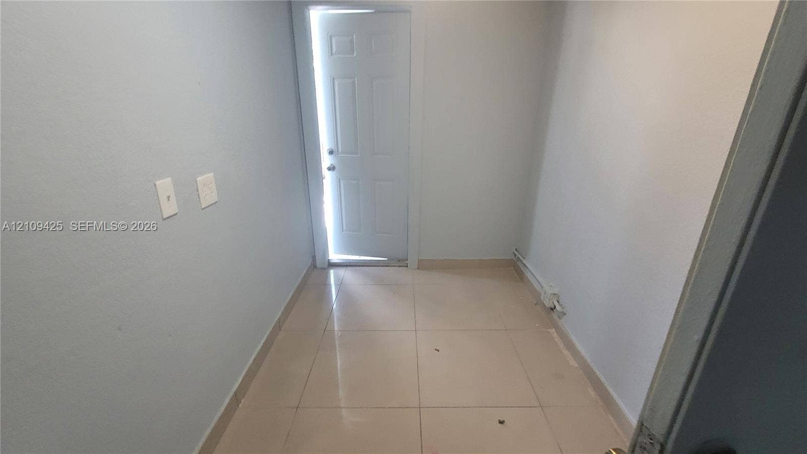 615 NW 25th Court, #B, Miami, Miami, FL 33125 Interior space featuring neutral wall paint, large-format tile flooring, and a six-panel exterior door