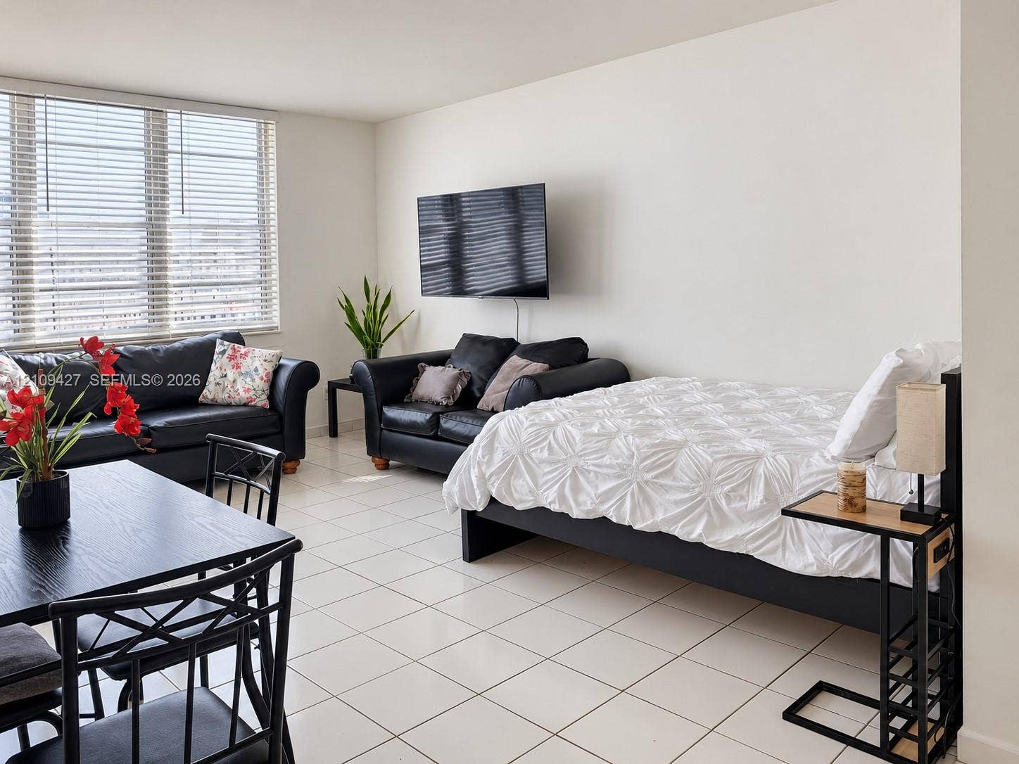 Neutral-toned interior featuring large-format ceramic tile flooring and floor-to-ceiling windows with integrated horizontal blinds
