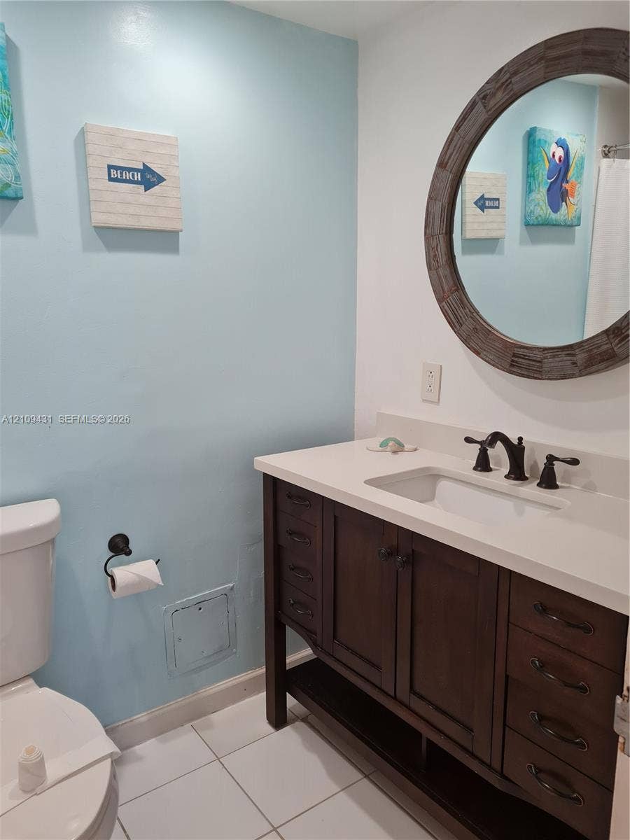 3001 S Ocean Drive, #619, Hollywood, Hollywood, FL 33019 Kitchen featuring wood-finish cabinetry, dark solid-surface countertops, black appliances, tile flooring, and multi-directional track lighting
