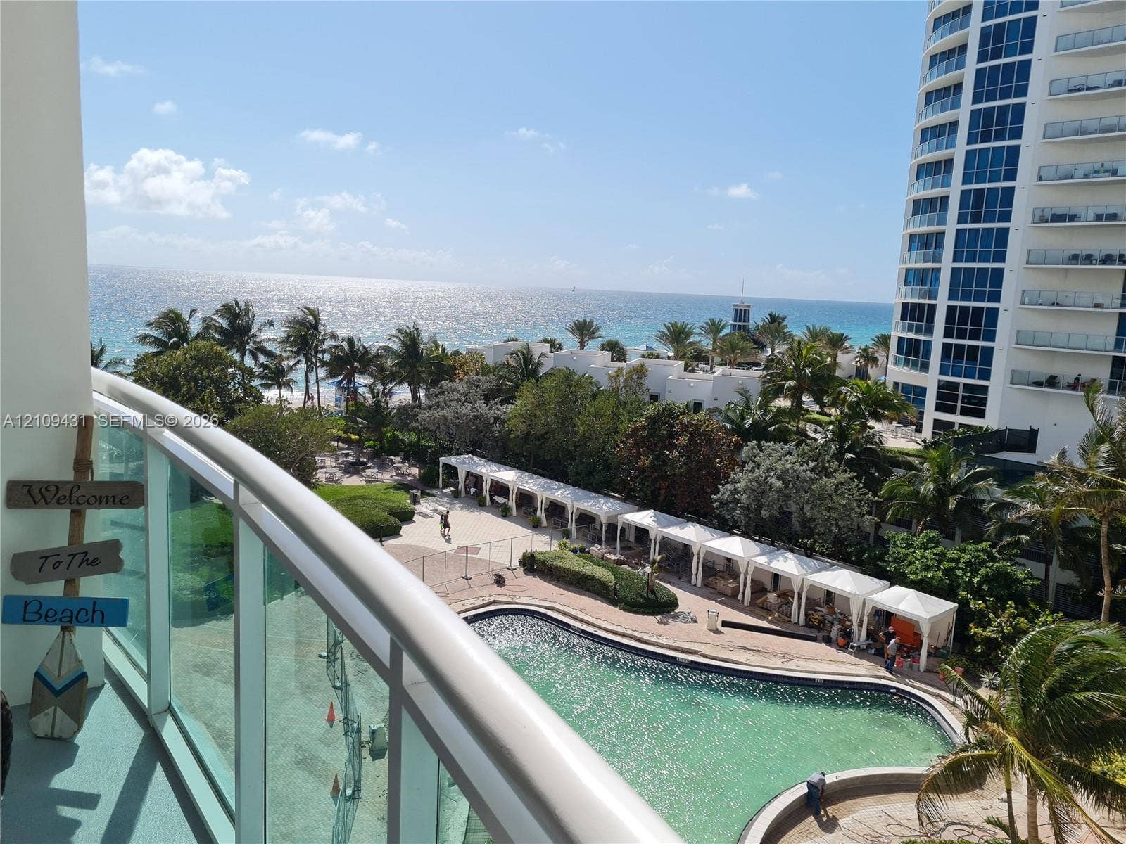 3001 S Ocean Drive, #619, Hollywood, Hollywood, FL 33019 Balcony featuring a glass railing, overlooking an outdoor pool, cabanas, and ocean shoreline