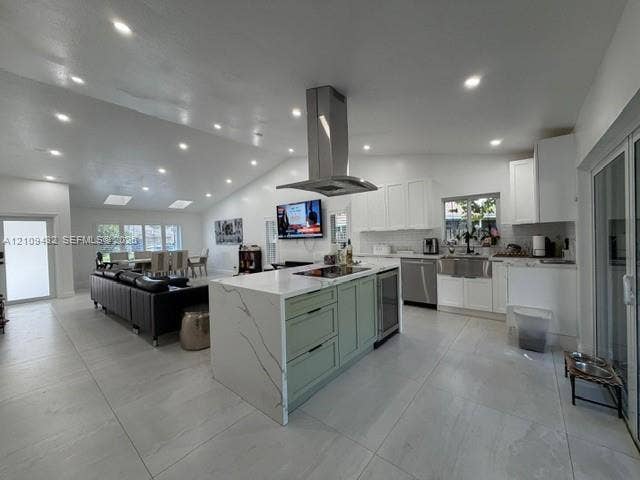 254 NW 107th Terrace, Coral Springs, FL 33071 Open-concept interior featuring vaulted ceilings, oversized kitchen island with stone-finish countertops, stainless steel chimney-style range hood, farmhouse sink, and large-format tile flooring