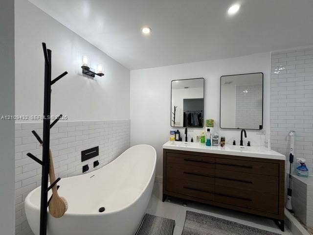 254 NW 107th Terrace, Coral Springs, FL 33071 Freestanding soaking tub with wall-mounted matte black fixtures, double-sink vanity with a countertop, subway tile backsplash, and recessed lighting