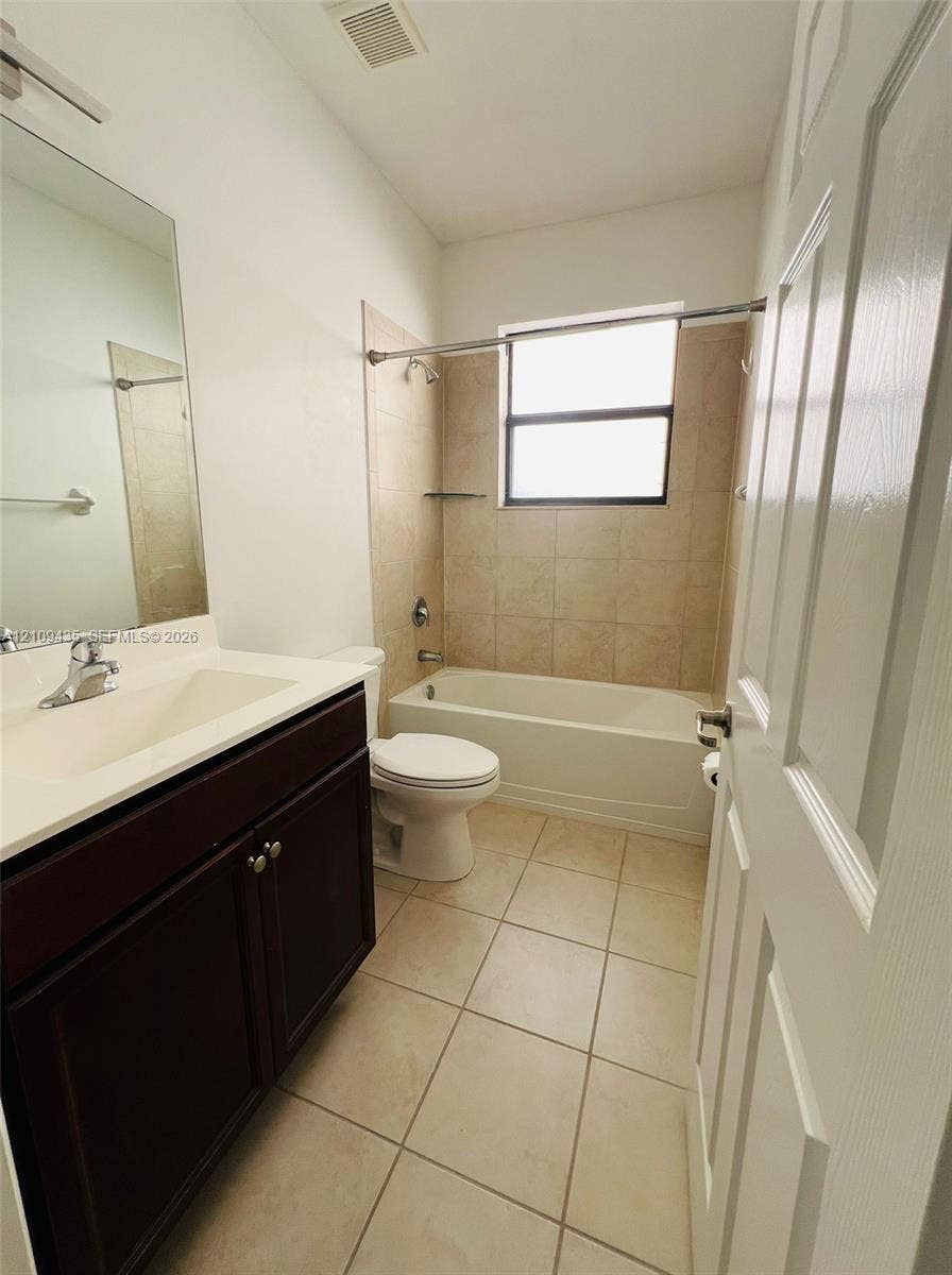 24161 SW 115th Court, #1, Homestead, Homestead, FL 33032 Bathroom featuring a vanity with a white integrated countertop, dark cabinetry, tile flooring, and a tub-shower combination with tiled walls