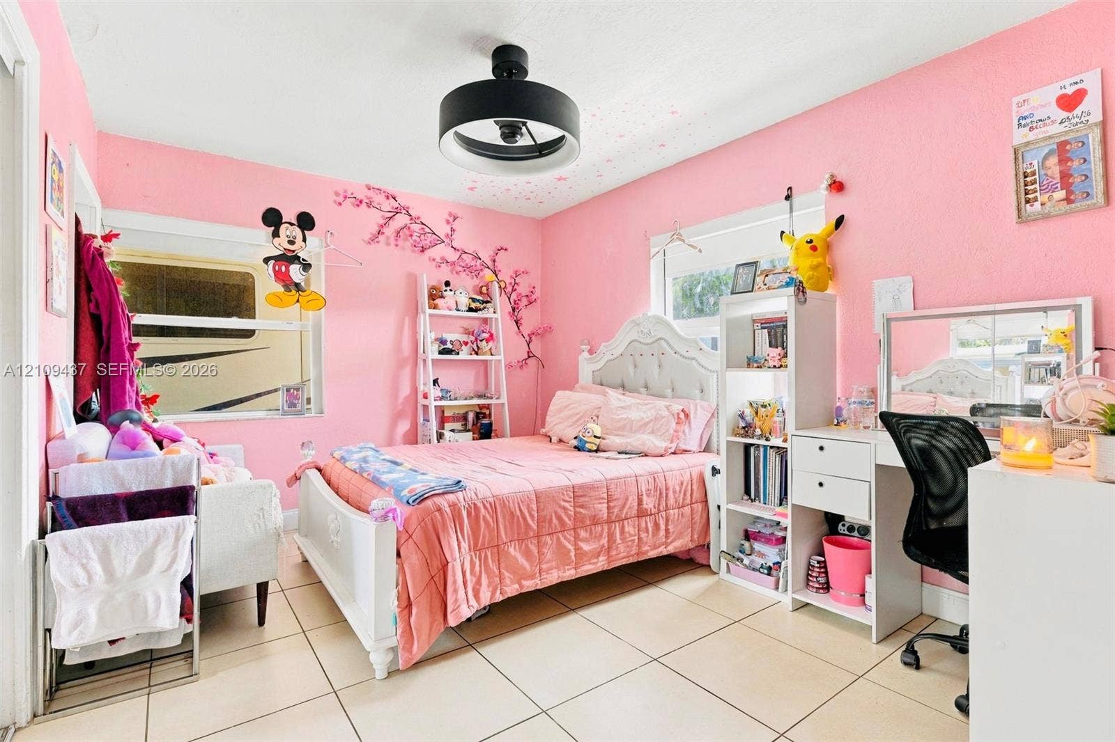 Bedroom featuring ceramic tile flooring, dual windows, and a circular drum-style ceiling light fixture