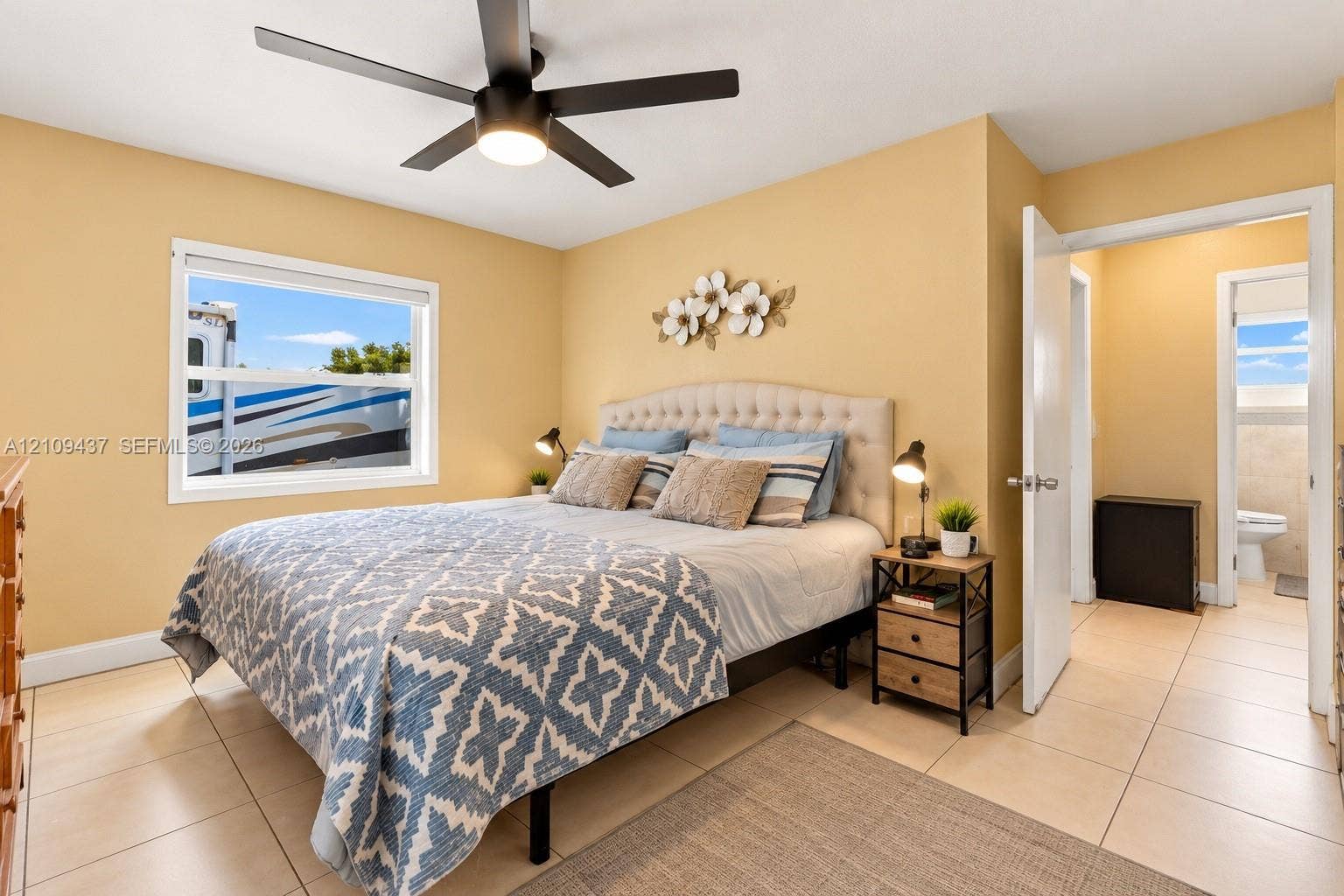 Bedroom featuring neutral wall paint, large-format tile flooring, and a ceiling fan with integrated lighting