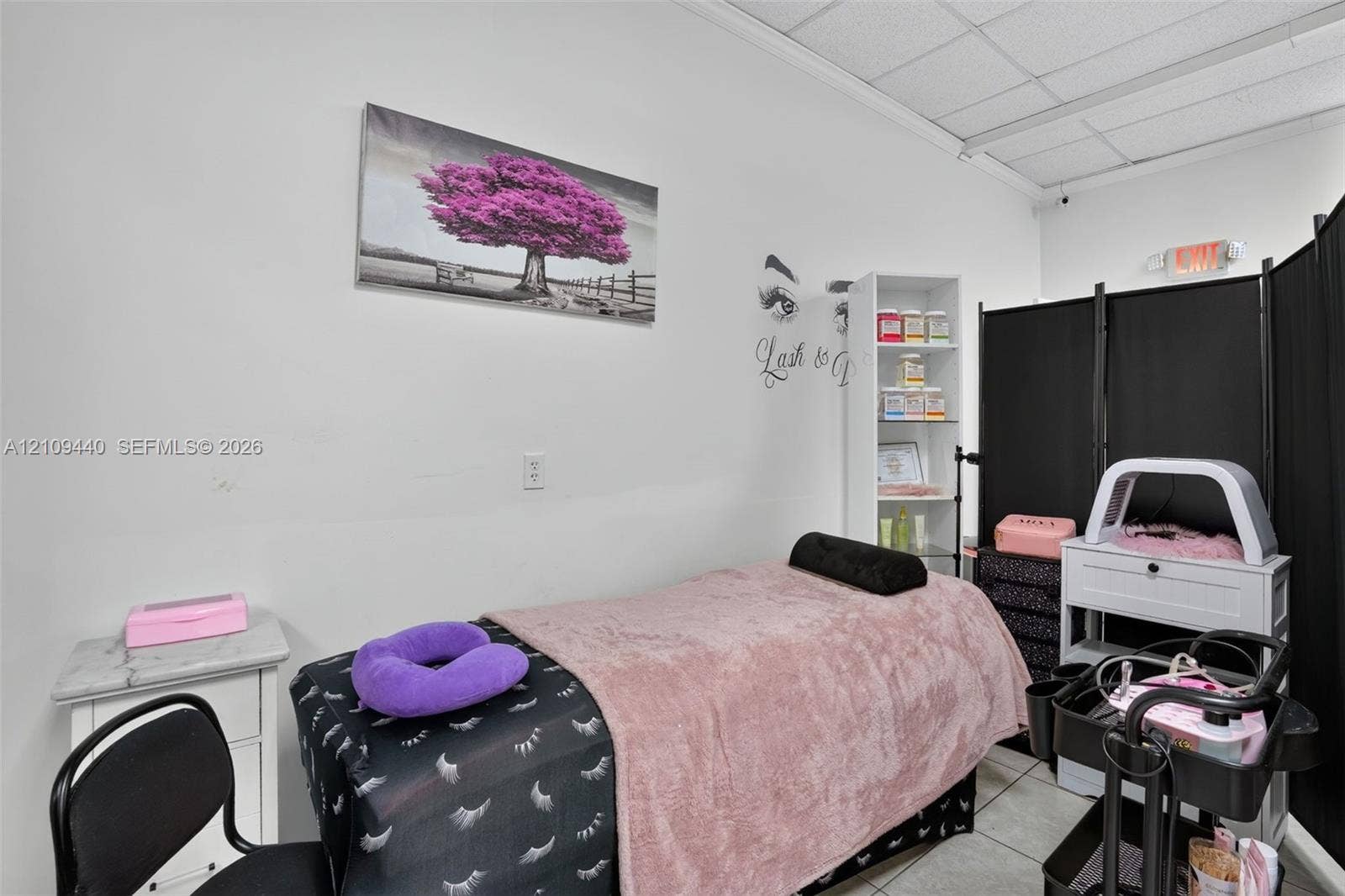 Interior space featuring high ceilings with integrated drop-ceiling tiles and neutral wall finishes