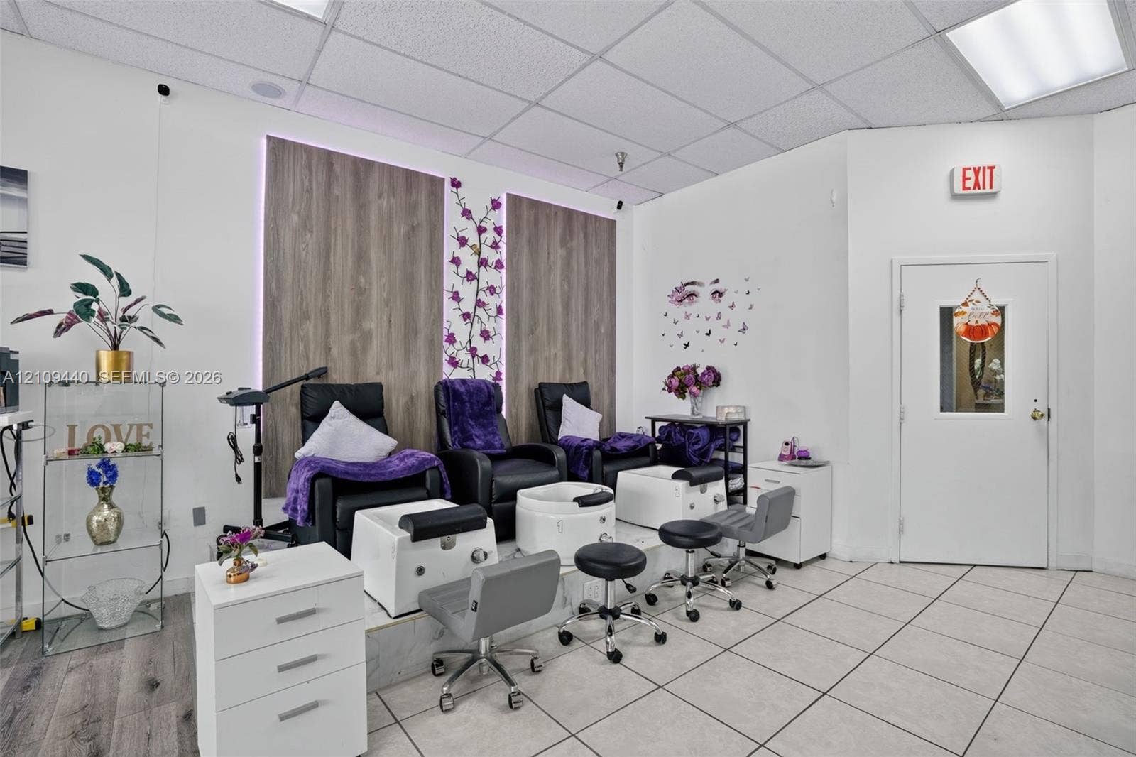 Professional workspace featuring wood-finish wall paneling, tiered elevated platform, drop ceiling with integrated lighting, and tile flooring