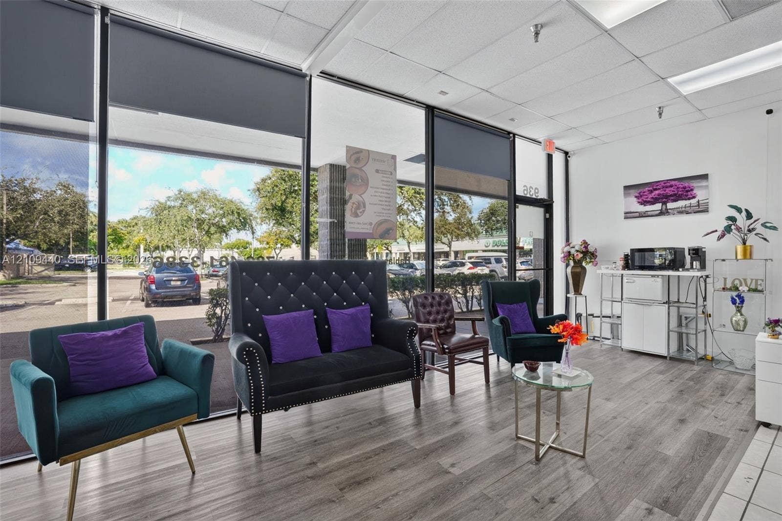 Expansive floor-to-ceiling glass storefront windows, wood-finish flooring, and recessed ceiling lighting