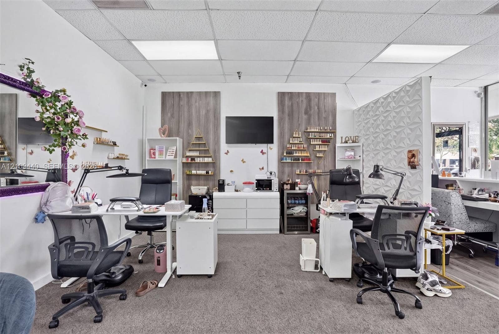 Commercial interior featuring acoustic drop ceiling panels, wood-finish wall paneling, and a three-dimensional geometric accent wall