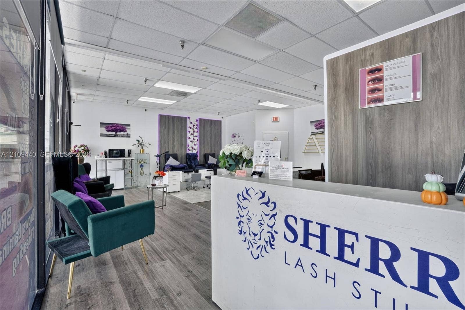Commercial space featuring wood-finish flooring, drop ceiling with recessed lighting, and built-in service reception desk
