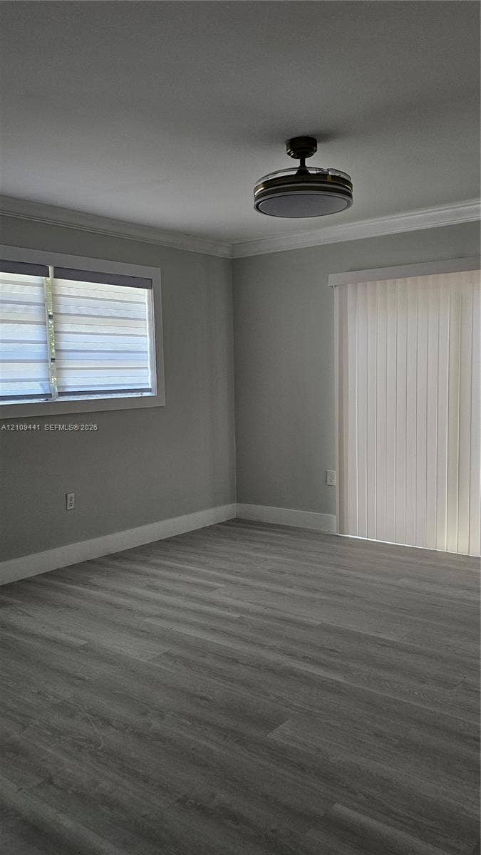 Interior room featuring wood-finish flooring, neutral wall tones, a recessed ceiling fan with integrated lighting, a sliding glass door, and a horizontal window with adjustable blinds