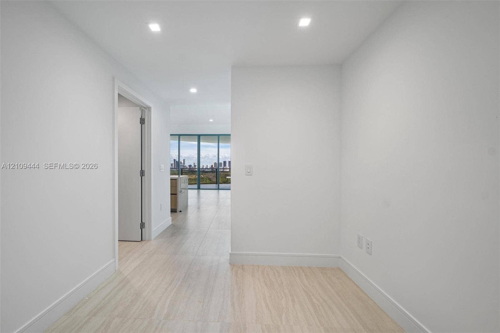 Interior space featuring large-format tile flooring, recessed lighting, and expansive floor-to-ceiling windows