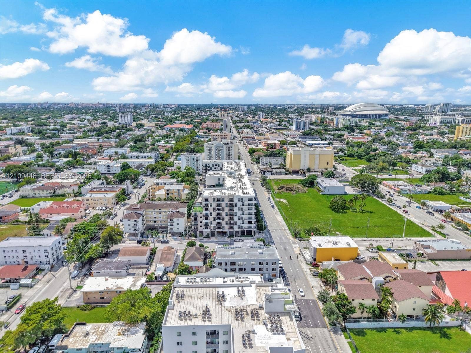 676 SW 1st Street, Miami, FL 33130 Aerial perspective of a multi-story urban residential building featuring a flat roof with exterior mechanical units and a grid of private balconies