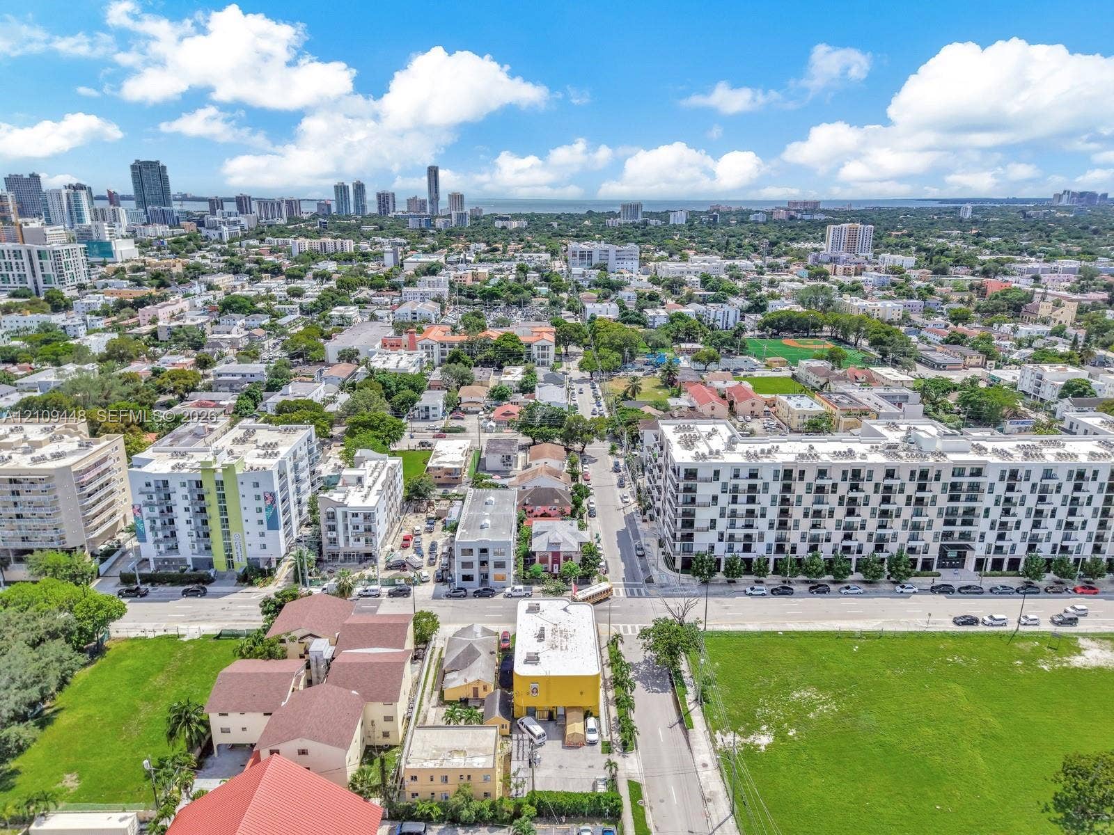 676 SW 1st Street, Miami, FL 33130 Aerial perspective of the urban landscape featuring mid-rise residential structures, extensive street grid infrastructure, and integrated green spaces