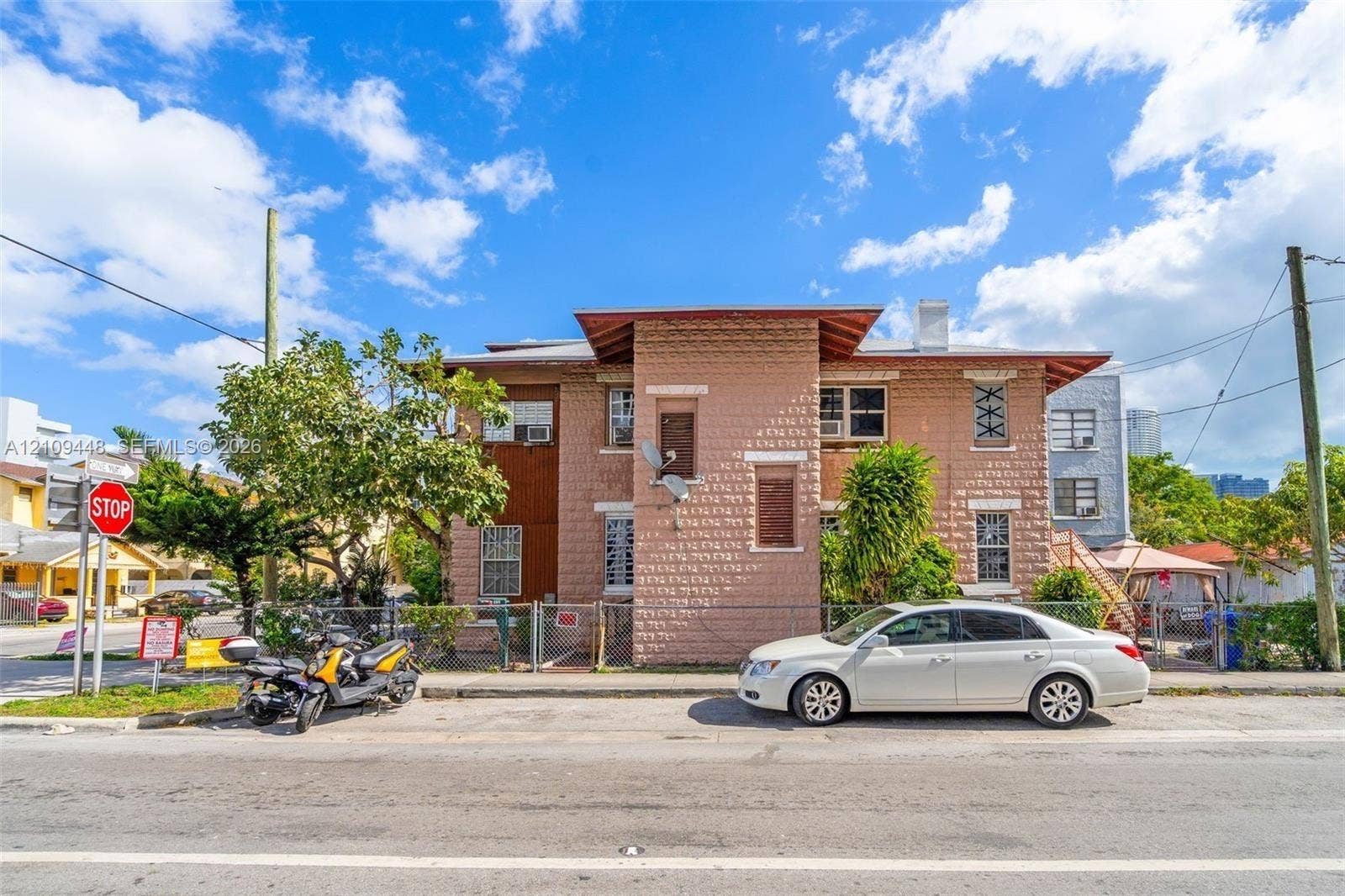 676 SW 1st Street, Miami, FL 33130 Two-story masonry exterior featuring textured stone-block siding, deep roof eaves, and multi-light window configurations