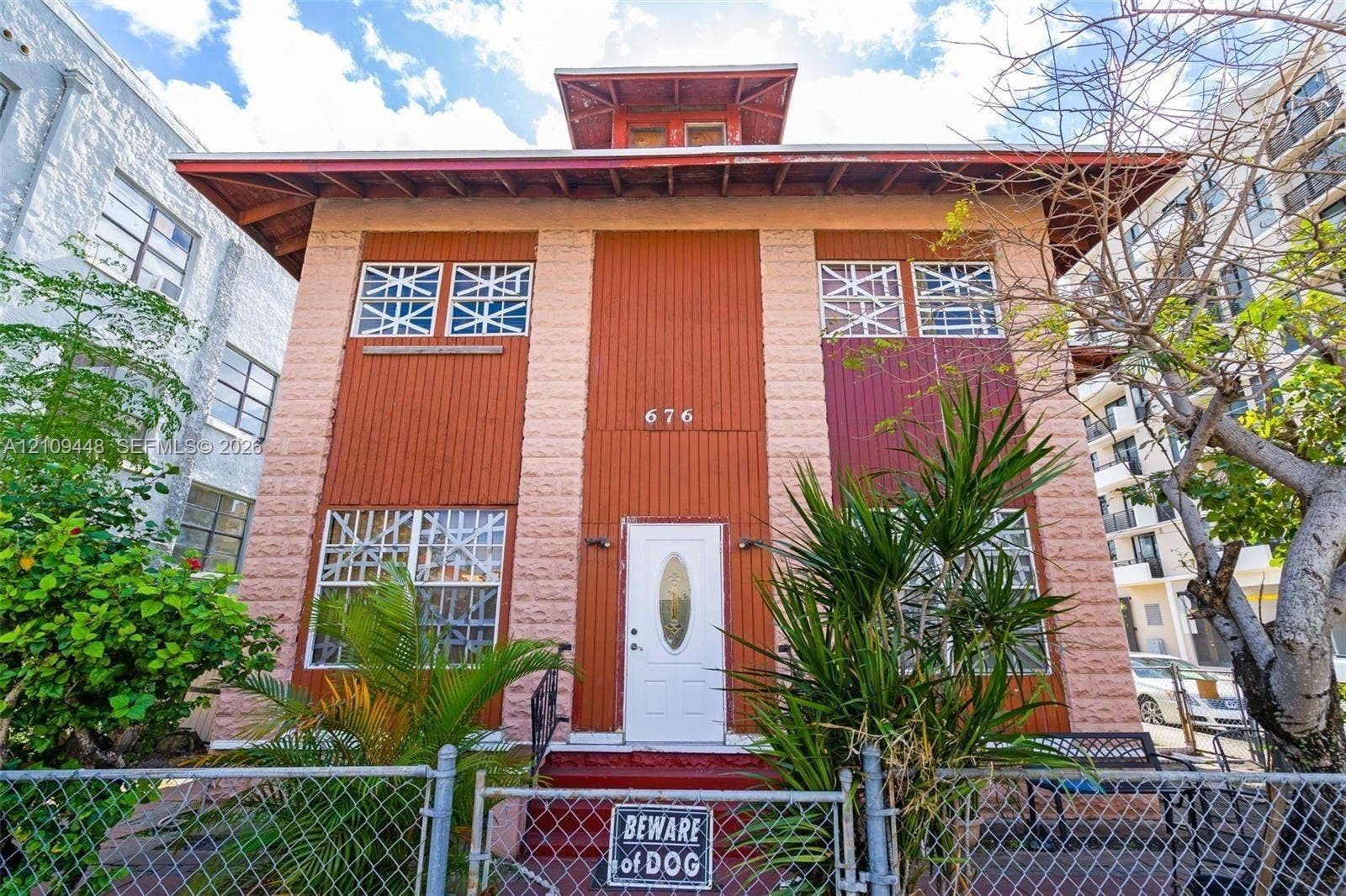 676 SW 1st Street, Miami, FL 33130 Multi-story exterior featuring a textured masonry facade, vertical panel siding, a roof cupola, and windows with decorative exterior cross-bracing