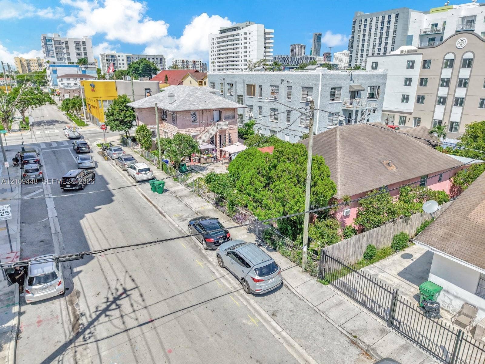 676 SW 1st Street, Miami, FL 33130 Corner lot property featuring a masonry exterior, private perimeter fencing, and established mature landscaping