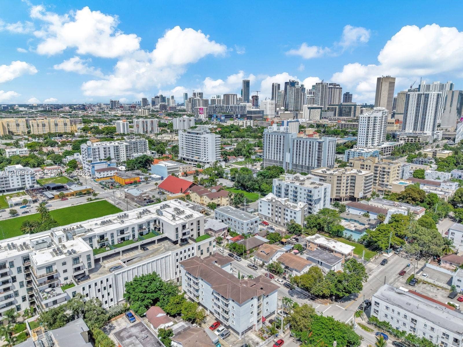676 SW 1st Street, Miami, FL 33130 Aerial perspective of a multi-story residential building featuring a structured parking facility, flat roof architecture, and proximity to the urban skyline