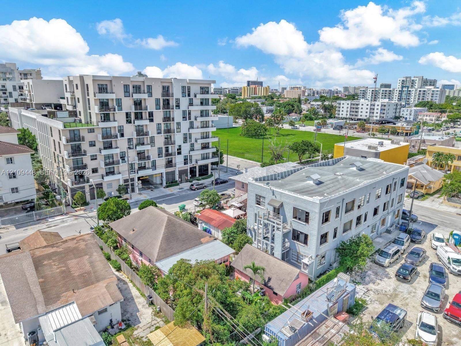 676 SW 1st Street, Miami, FL 33130 Aerial perspective of a multi-story urban residential building featuring a light-toned exterior facade, grid-pattern fenestration, and private balconies